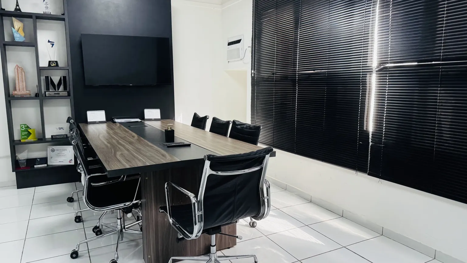 Segunda sala de reunião do andar, com marcenaria e iluminação natural
